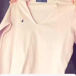 Beige tröja från Ralph Lauren - Säljer en stilren beige tröja från Ralph Lauren med v-ringning och det klassiska logotypbroderiet på bröstet. Perfekt för en avslappnad men elegant look.