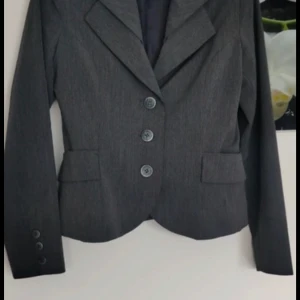 Grå kavaj från Orsay - Snygg grå kavaj från Orsay med klassisk design.