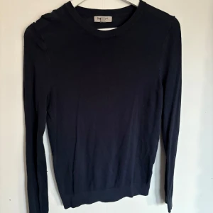 Mörkblå långärmad tröja - Säljer en stilren mörkblå långärmad tröja. Perfekt för en minimalistisk look och passar till det mesta. Tröjan har en klassisk rund hals och är gjord i ett mjukt material.