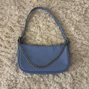 Ljusblå axelväska från H&M Divided - Snygg ljusblå axelväska från H&M Divided med krokodilmönster. 