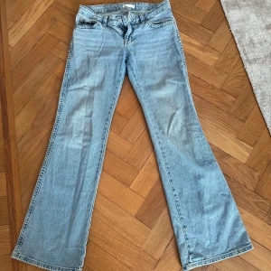 Low-waist bootcut jeans från Ginatricot - Snygga ljusblå low-waist jeans från Ginatricot. De har en bootcut-stil som ger en retro känsla och är perfekta för en avslappnad look. Jeansen har en knapp och dragkedja framtill💕
