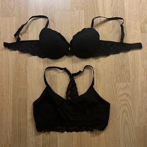 Svarta spetsdetaljerade BH:ar - Två svarta BH:ar med spetsdetaljer. Den ena har vadderade kupor och justerbara axelband, medan den andra är en mjuk bralette med spetsrygg. Perfekta för en stilren och bekväm look. Storlek 75B. 50kr styck. Knappt använda!!