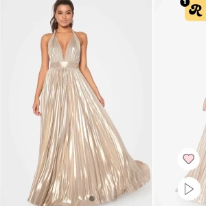 Champagnefärgad balklänning - Elegant guldig balklänning med halterneck och öppen rygg. Klänningen har ett vackert fall och glänsande material som ger en lyxig känsla. Perfekt för balen och passar mig som är 160 som referens. Lite missfärgad längst ner men inget man lägger märket till💞