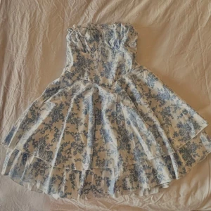 Blåvit blommig sommarklänning - En superfin sommarklänning med korset. Den har aldrig använts då den va lite för stor. 