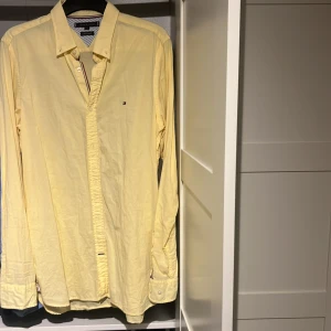 Gul Tommy Hilfiger skjorta - Snygg gul skjorta från Tommy Hilfiger i storlek L. Tillverkad i en skön blandning av bomull och linne. Skjortan har långa ärmar och knappar framtill. Perfekt för en stilren look till sommaren. Inga defekter!. Priset går att diskutera.