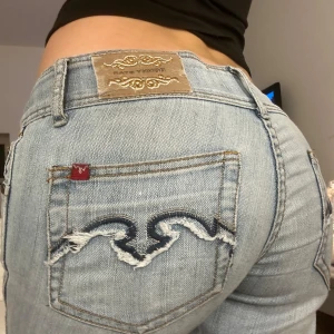 Lågmidjade jeans - Lågmidjade bootcut jeans med coola broderade detaljer på bakfickorna. Använda antal gånger men inga defekter! Jag på bilden är 170🥰