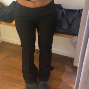 Lågmidjade kostymbyxor BikBok  - Snygga svarta bootcut kostym byxor med en tight passform upptill och utsvängda ben. Perfekta för en stilren look. Passar bra till både vardag och fest. Storlek 34. Har aldrig använt innan helt nya utan prislapp.