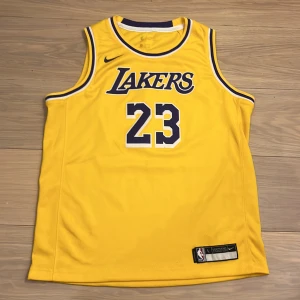 Gul Lakers basketlinne från Nike - Säljer ett Lebron James basketlinne från Nike med nummer 23. Nypris är 1000 kr. Den är oanvänd och i nyskick. Pris kan diskuteras.