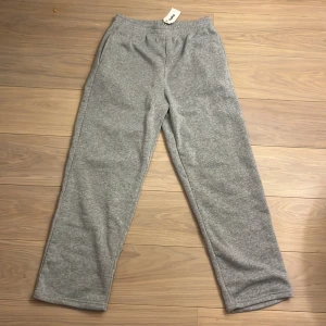 Grå mjukisbyxor från Oukku - Säljer ett par bekväma grå mjukisbyxor från Oukku. Byxorna har en elastisk midja och är perfekta för en avslappnad stil. De är designade i California och har en rak passform.