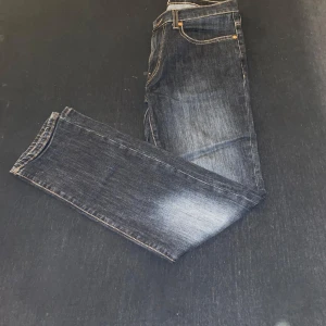 Blå jeans från Grant - Säljer ett par klassiska blå jeans från Grant med regular fit. De har en traditionell femficksdesign och en snygg tvättad look. Perfekta för en avslappnad stil.