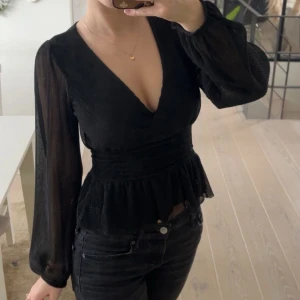 Svart blus med v-ringning - Svart blus, den är även lite smått glittrig men det syns inte så bra i kameran. Använd 1 gång.