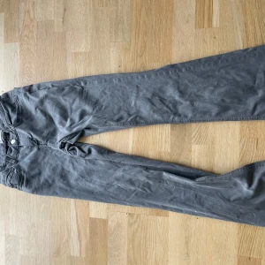 Grå byxor - Snygga grå byxor med bootcut-stil. Perfekta för en avslappnad look. De har en klassisk design med knapp och dragkedja framtill.