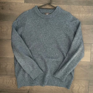 Blå stickad tröja från H&M - Säljer en stilren grå stickad tröja från H&M. Perfekt för kyligare dagar med sin mjuka och bekväma passform. Tröjan har långa ärmar och i hyfsat tjockt tyg. Den är knappt använd och är i väldigt bra skick! Modellen är 180cm och väger 70kg 