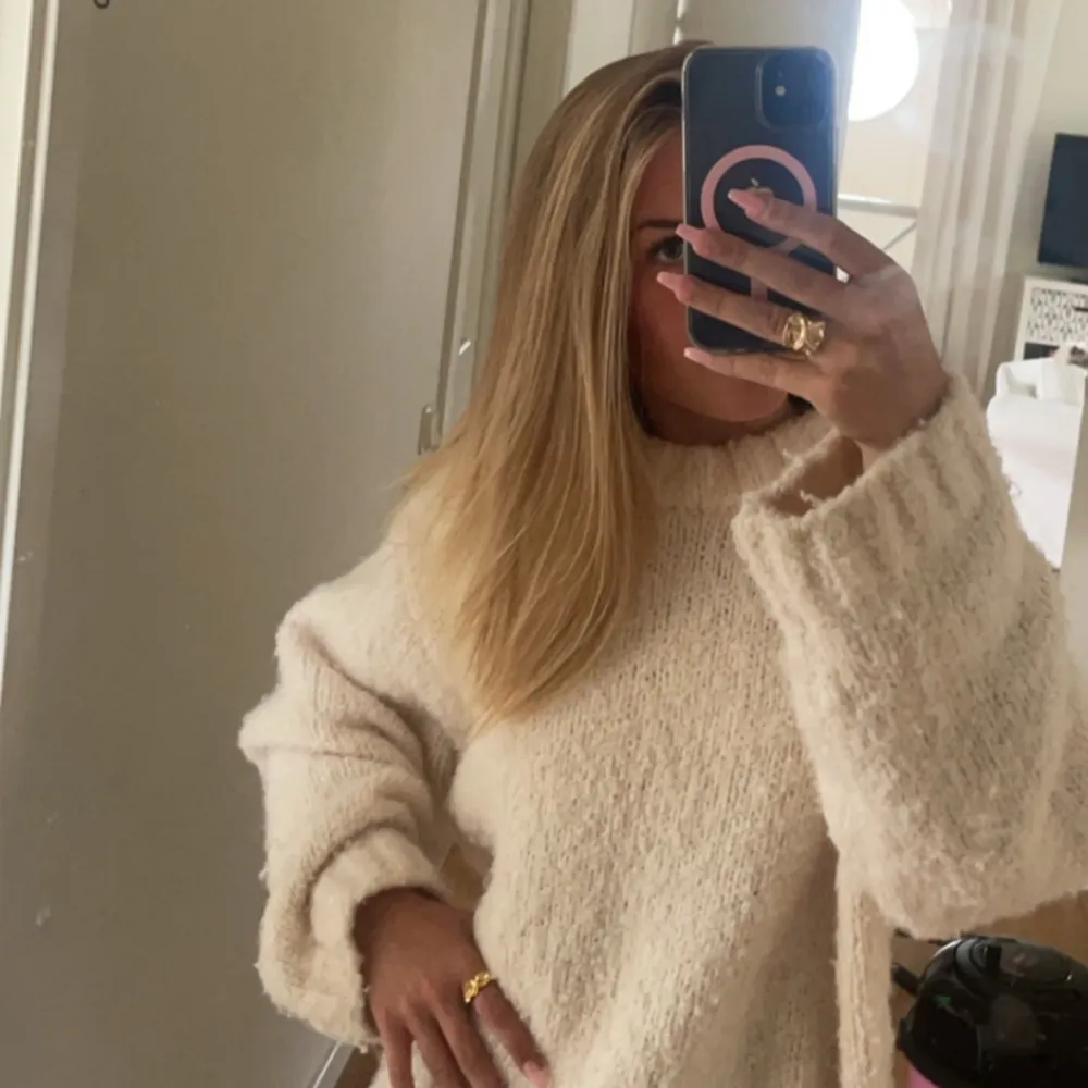 Mysig vit tröja med långärmad design. Perfekt för kyliga dagar med sin fluffiga och bekväma stil. Enkel och stilren, passar till många olika outfits.. Neuletakit & Villapaidat.