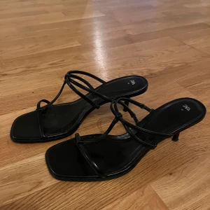 Svarta heels från Zara - Snygga svarta klackskor från Zara med smala remmar och en elegant klack. Perfekta för en stilren look.