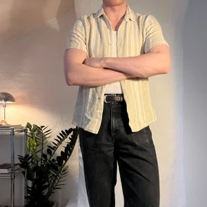 Kortärmad skjorta - Beige/randig skjorta från Zara. Stickat tyg. Size S men sitter lite större. Kika gärna andra annonser, samfrakta gärna.