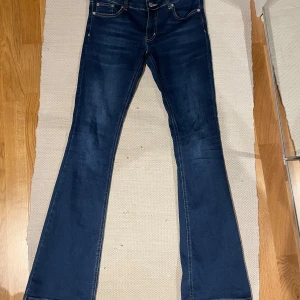 Mörkblå bootcut jeans från NLY Jeans - Snygga mörkblå bootcut jeans från NLY Jeans. De har en klassisk femficksdesign och är tillverkade i ett stretchigt denimtyg för extra komfort. Perfekta för en avslappnad stil. Hyfsat lågmidjade 