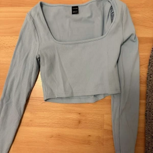 Svart croppad topp från Shein - Säljer en stilren svart croppad topp från Shein. Toppen har långa ärmar och en fyrkantig halsringning. Perfekt för att matcha med höga jeans eller kjol. Hör av dig vid intresse!