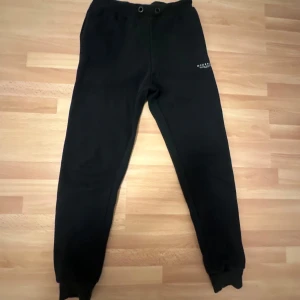 Svarta mjukisbyxor från McKenzie - Säljer ett par svarta mjukisbyxor från McKenzie. Byxorna har en elastisk midja och ribbade muddar vid bensluten. Perfekta för en avslappnad stil.