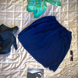 Mörkblå kjol - Säljer en mörkblå kjol med elastisk midja. Kjolen har en enkel och stilren design, perfekt för olika tillfällen. Den är knälång och har en luftig passform. Skulle säga en storlek L/XL Öppen för prisförslag! 