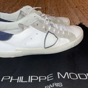 Philippe Model skor - Riktigt feta vita sneakers från Philippe Model-Skorna är i bra skick bortsett från en defekt på vänster skon(Se sista bild) Dustbag ingår-Vid övriga frågor eller funderingar är det bara att höra av sig!🙌✌️💯
