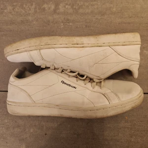 Vita sneakers från Reebok - Säljer ett par klassiska vita sneakers från Reebok. Skorna har en enkel design med snörning och Reebok-loggan på sidan och hälen. Perfekta för en stilren look.