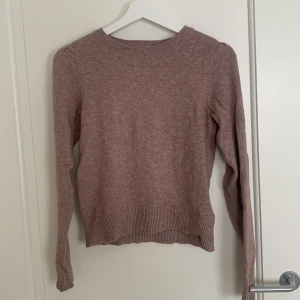 Rosa stickad tröja - Mysig rosa stickad tröja med rund hals och långa ärmar. Ribbstickade detaljer vid ärmslut och nederkant. Lite nopprig på vissa ställen. Nypris runt 300kr