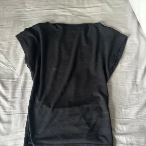 Svart t-shirt från Shein - Säljer en svart t-shirt från Shein med korta ärmar och en öppen rygg. Perfekt för en stilren look. T-shirten är tillverkad i ett mjukt material som känns skönt mot huden. (Mer bilder? Kom privat!) 