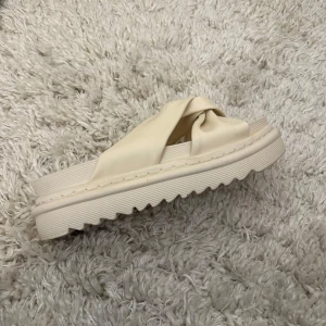 Beige sandaler med knutdetalj - Snygga beige sandaler med en unik knutdetalj på ovansidan. De har en tjock sula med räfflad undersida för extra grepp. Perfekta för en avslappnad stil.