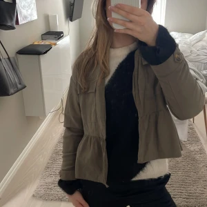 Olivgrön jacka med knappar - Säljer en olivgrön jacka med knappar framtill. Jackan har en loose passform och är perfekt för höst och vår. Den har långa ärmar och en stilren design som funkar till många outfits.