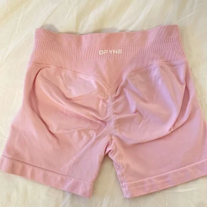 Rosa dfyne shorts  - Rosa dfyne shorts impact modell. Storlek xs. Bra skick förutom en liten fläck, se sista bilden, går säkert bort inte testat. Kvitto från hemsidan finns om man vill se det