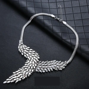 Silverfärgat halsband med fjäderdesign - Elegant silverfärgat halsband med en unik fjäderdesign som ger en känsla av rörelse och stil. Perfekt för att lyfta vilken outfit som helst med sin glänsande finish och detaljerade utformning.