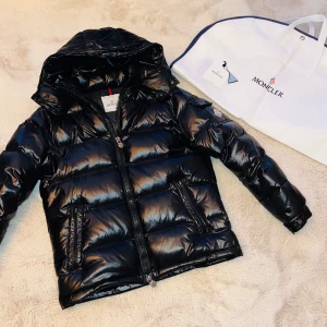 Moncler Jacka - Säljer en snygg svart Moncler jacka. Använd 1 vinter och den är i nyskick. Kommer med en praktisk förvaringspåse.