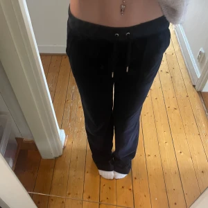 Marin blåa Juicy couture byxor - Säljer ett par marin blåa mjukisbyxor med snörning i midjan. Jag säljer dessa för att dem e för stora där jag valde fel storlek och dem är använda flertal gånger och på den sista bilden så ser man att byxorna har blivit använda. Metallen på snöret har rostat vilket jag visar på tredje bilden. Jag skickar endast inom instabox! Pris kan diskuteras💕