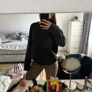 Mörkgrå stickad tröja - Säljer en mysig mörkgrå stickad tröja med långa ärmar. Perfekt för kyligare dagar och enkel att matcha med olika outfits.