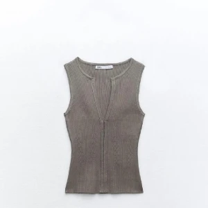 Grå zara topp - Snygg beige ribbad linnetopp från Zara med v-ringning. Perfekt för varma dagar och enkel att matcha med olika outfits. Storlek L men passar mig som brukar ha S/M💕