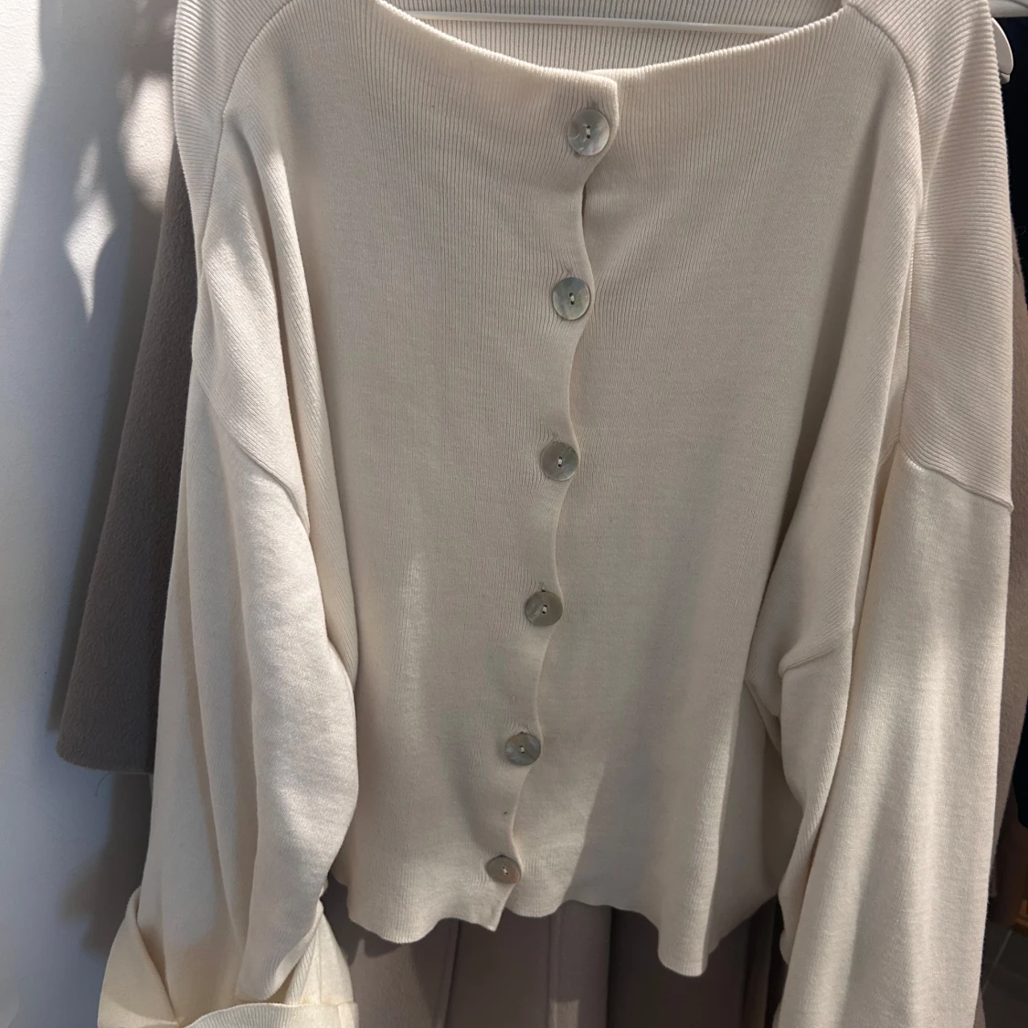 Krämvit kofta med pärlemorknappar - 1