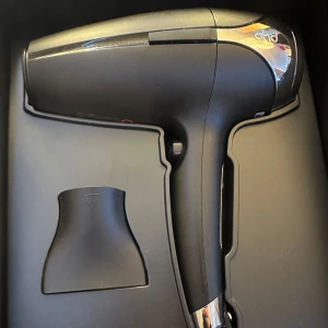 ghd Helios hårfön i svart och silver - Säljer en ghd Helios hårfön i svart med silvriga detaljer. Ergonomisk design med smal fönpip för precis styling. Perfekt för att snabbt torka och forma håret med professionellt resultat. Nypris mellan 1800-2000kr. Mitt pris 1500, vid snabb affär kan pris diskuteras!