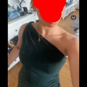 Rosa långklänning med slits och oneshoulder - En grön balklänning med glitter jätte skön passar i längden som 160cm med halvkort slits. Och en Elegant långklänning i ljusrosa satin med oneshoulder-design och hög slits framtill. Klänningen har en figurnära passform och en mjuk glansig yta som ger en lyxig känsla.  350 för båda 150 för en.