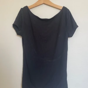 Svart topp med öppen rygg från Gina Tricot - Säljer en svart topp från Gina Tricot med korta ärmar och snygg öppen rygg. Perfekt för dig som vill ha en enkel men ändå stilren topp till garderoben. Mjuk och skön bomullskänsla. När jag strök tröjan blev det ett vitt sträck i mitten, därav priset😊