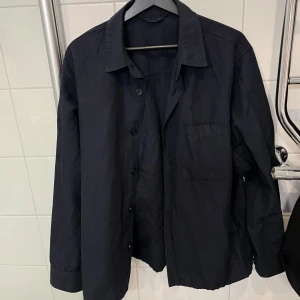 Overshirt från Uniqlo - Marinblå overshirt från uniqlo använd ett fåtal gånger, inga defekter. Overshirten är enligt mig relativt tunn, sitter bra på mig som brukar ha M. 
