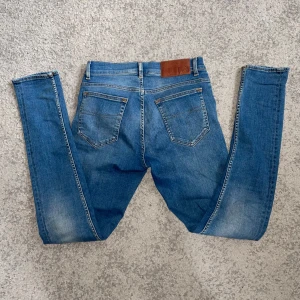 Blå slim fit jeans tiger of sweden - Säljer ett par blå slim fit jeans från tiger of sweden. Jeansen har en snygg tvätt och smal passform hela vägen ner. Väldigt bra skick och inga slitningar. Storlek 28/30, är även väldigt stretchiga.