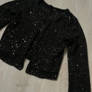 Svart paljettkofta - Säljer en svart sticksd kofta med paljetter och trekvartsärm. Perfekt både till fest och vardags🌟