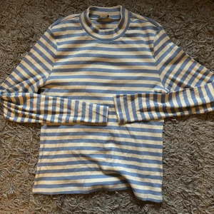 Randig långärmad tröja från Monki - Säljer en ribbad långärmad tröja från Monki i storlek M. Tröjan har blå och vita ränder och en rund halsringning. Perfekt för dig som gillar en enkel men snygg stil. Supermjuk och skön att ha på sig! Endast testad💙🤍