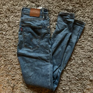 Levi's Mile High Super Skinny jeans - Säljer ett par klassiska blå Levi's Mile High Super Skinny jeans med hög midja. Jeansen har fem fickor och den ikoniska röda Levi's-lappen på bakfickan. Perfekta för dig som gillar en tight passform och stilren look🩵