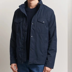 Mörkblå jacka från J.Lindeberg - Säljer en schysst mörkblå jacka från J.Lindeberg, väldigt snygg både till våren/hösten! Den är väldigt sparsamt använd och har inga märken/skador eller annat! Den är i storlek L, nypris ligger på ungefär 3400kr