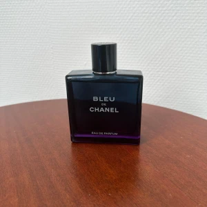 Bleu de Chanel Eau de Parfum 100 ml - Bleu de Chanel Eau de Parfum är en elegant herrdoft i en stilren, mörkblå glasflaska med silverfärgad kork. Flaskan rymmer 100 ml och har en modern, maskulin design med tydlig logotyp framtill.