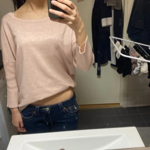 Ljusrosa stickad tröja - Säljer en ljusrosa stickad tröja med rund halsringning och långa ärmar. Tröjan har en avslappnad passform och är perfekt för lager-på-lager. Enkel och stilren design som passar till mycket.