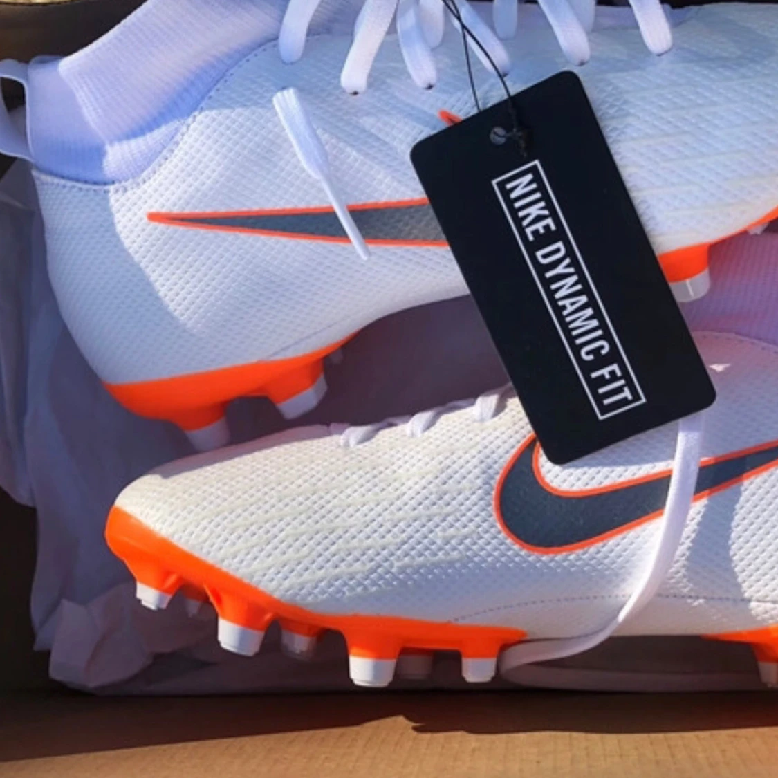 Vita och orangea Nike fotbollsskor