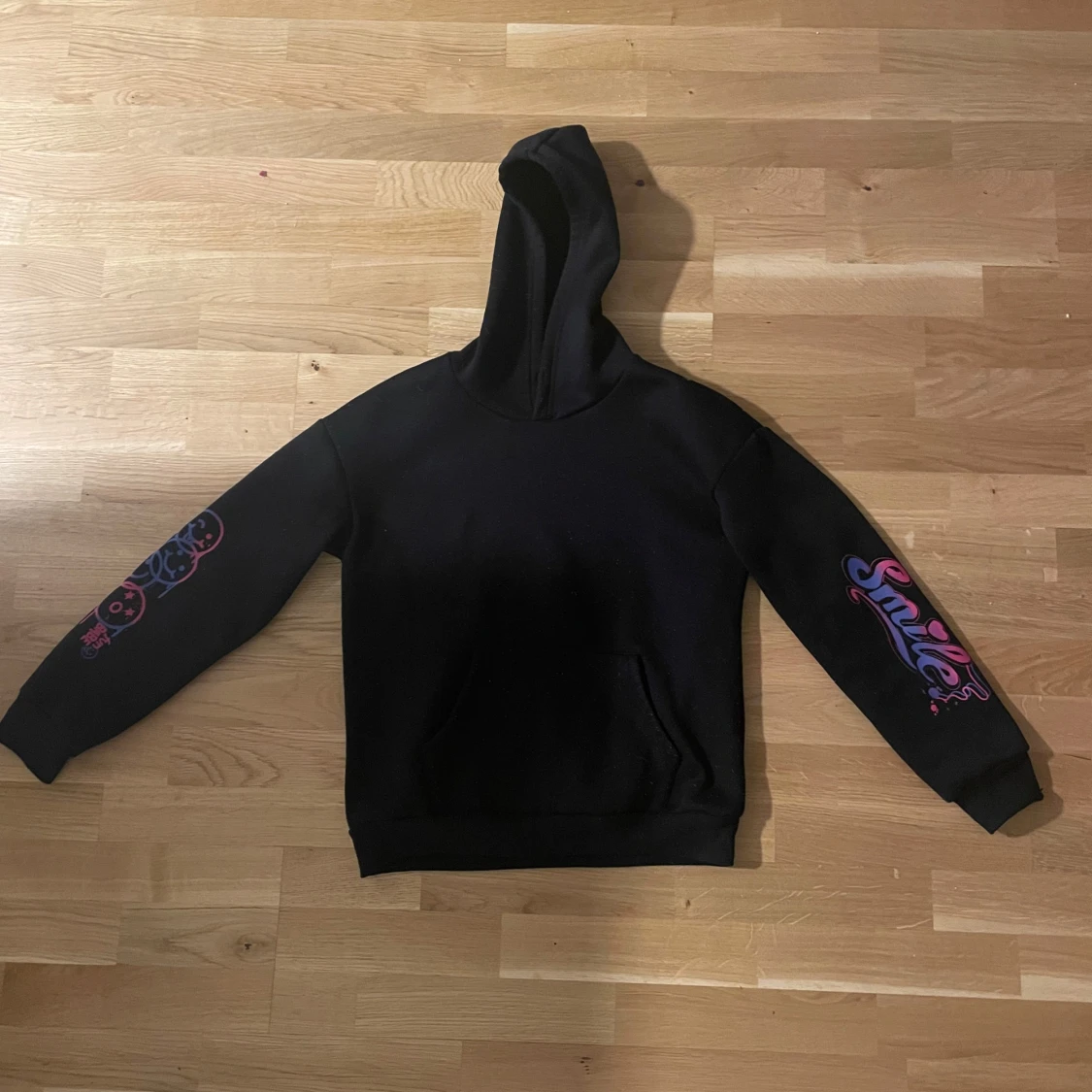 Svart hoodie med färgglada tryck
